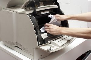 person un-jamming a copier
